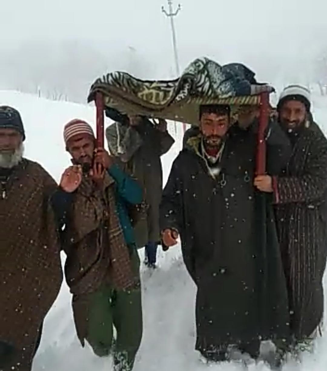 As snowfall block roads, villagers carry patient on make-shift stretcher to reach hospital in Chandoosa Bla