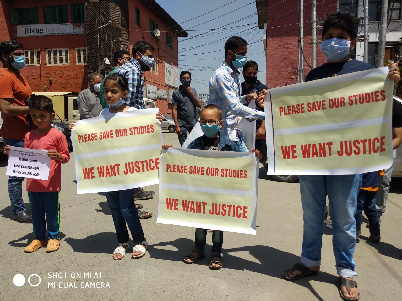 Shopkeepers protest along with their children after their shops handed over to ex-service men