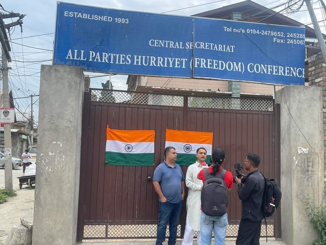 Political activist Sandeep Mawa affixes national flag on Hurriyat Conference office in Srinagar