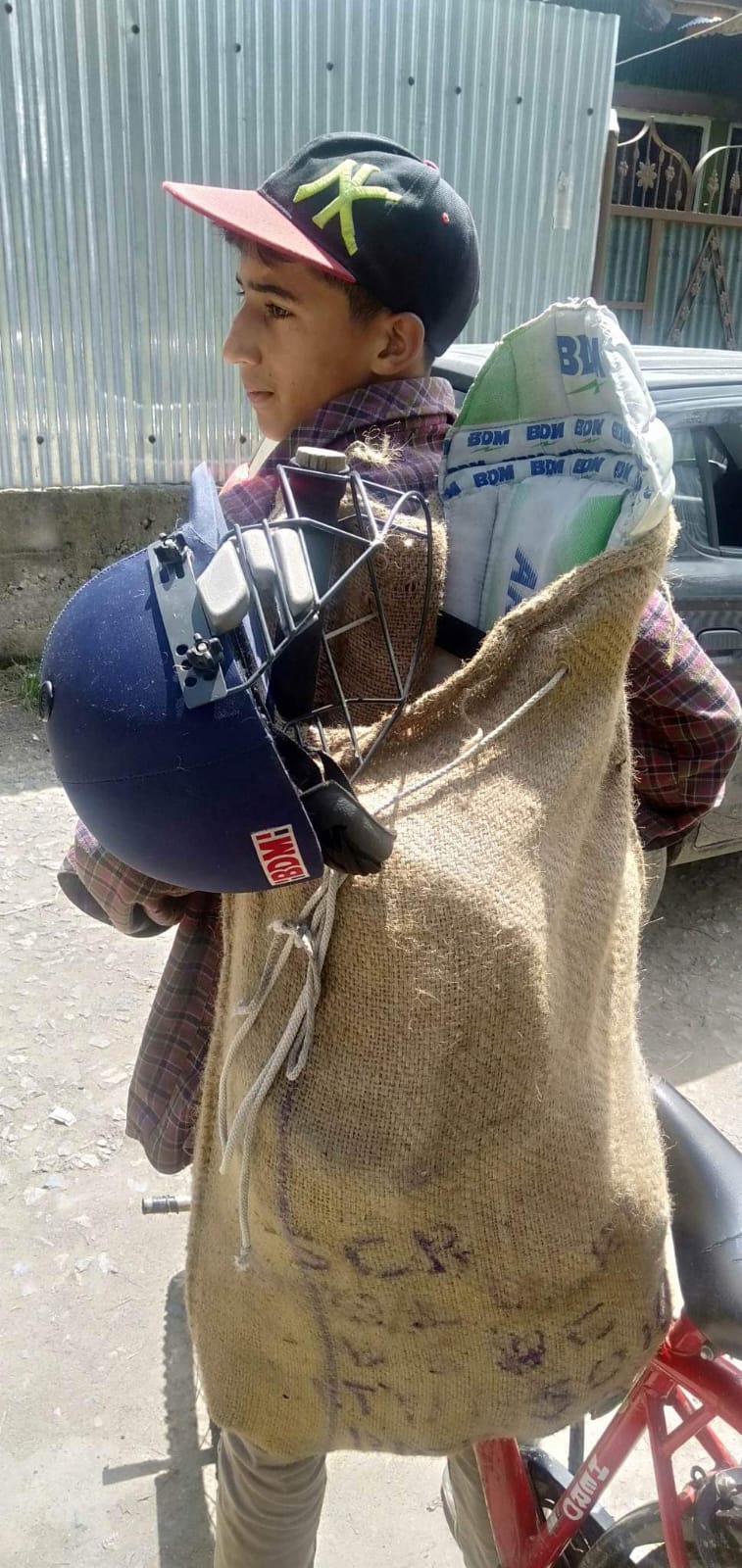 Young boy carrying sports items in rice bag wins hearts on internet